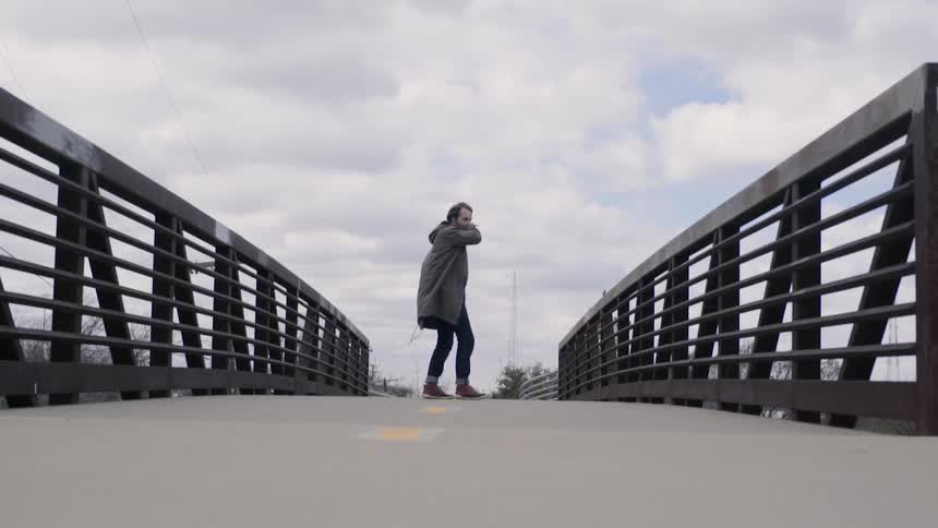 A man is standing on a bridge