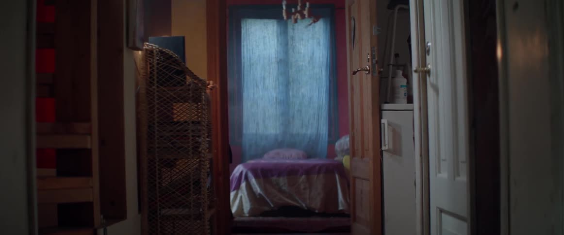 A perspective view looking through an open doorway into a colorful rustic bedroom.