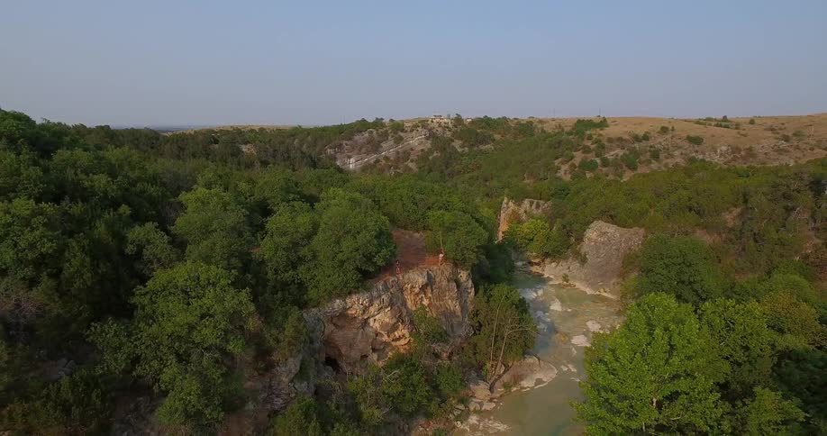 People stand on the edge overlooking a stream