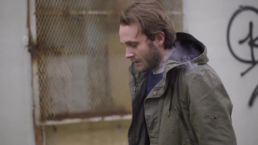 Smoke emerges from a man's jacket