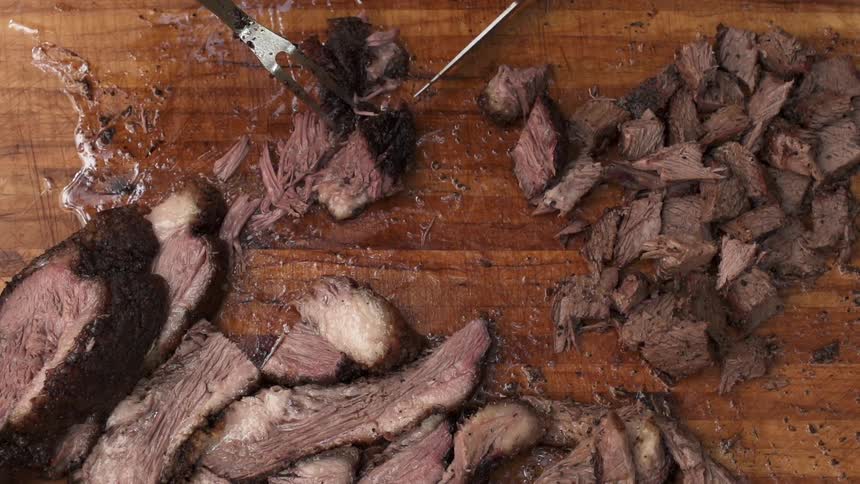 Beef is sliced on a cutting board