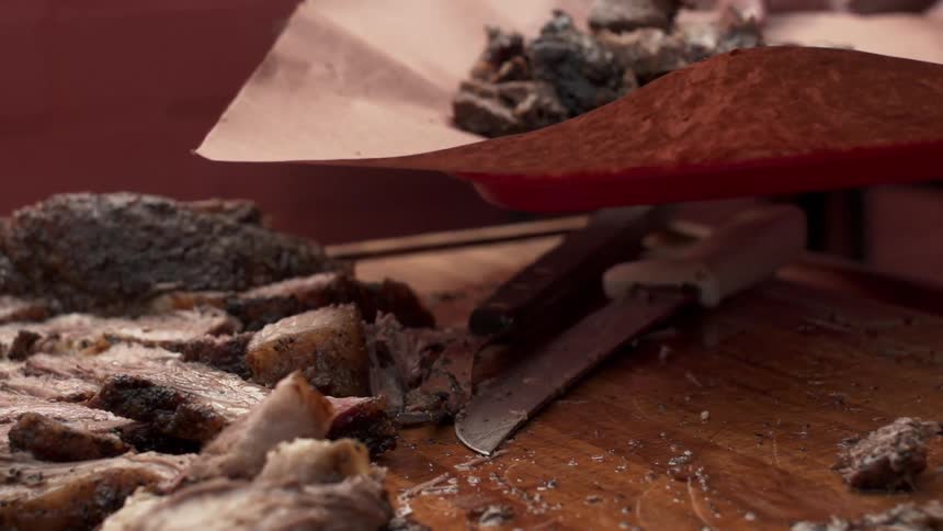A person is scooping up cut food onto a plate