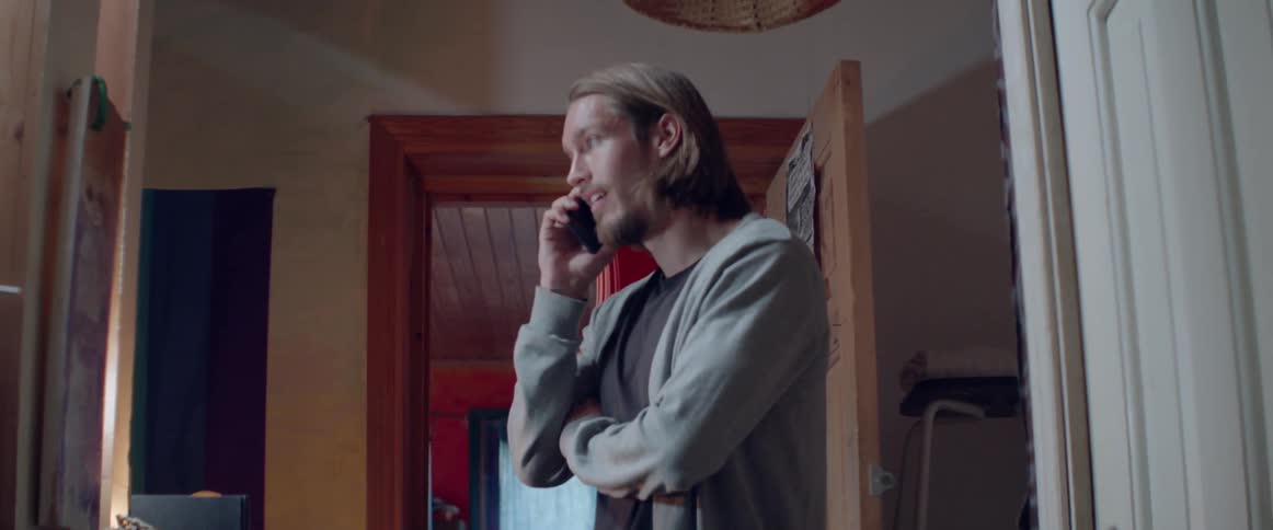 A thoughtful person listens to someone while holding a cellphone to his ear.