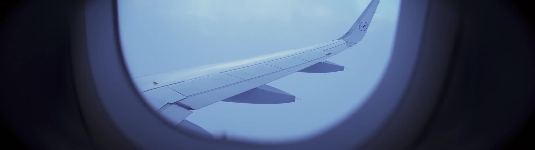 The plane is flying high in the cloudy sky