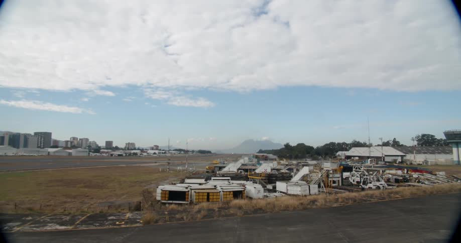 Buildings and storage units sit under a cloudy blue sky