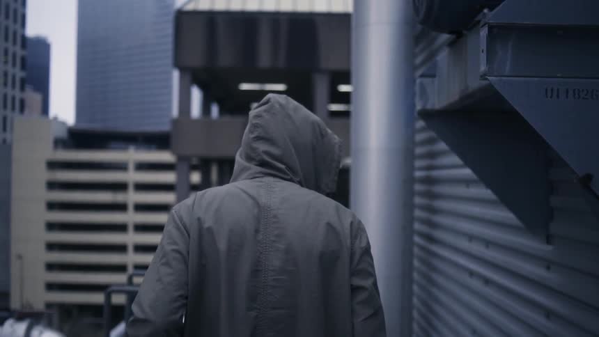 Man walking outside with buildings all around him