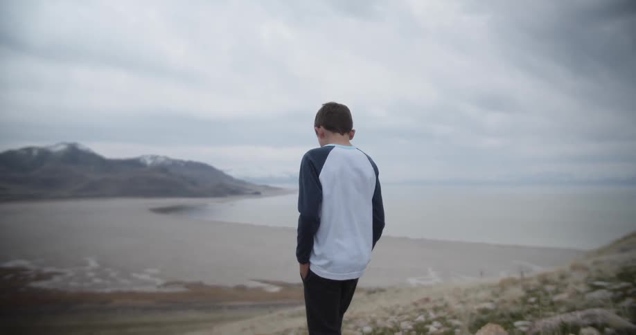 Child walks on the beach towards the water