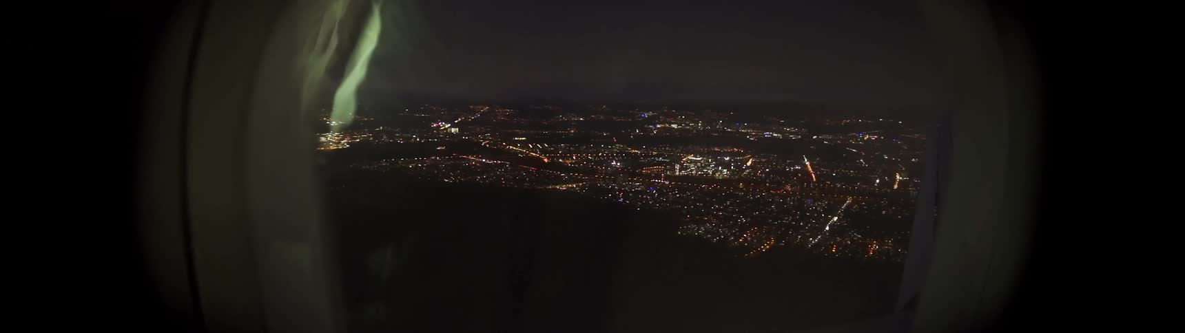 An airplane is flying over a city at night