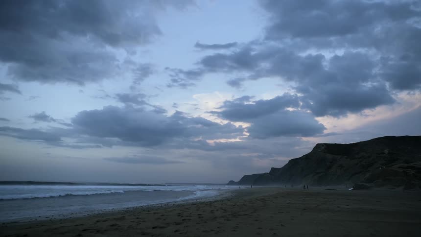 The sun is setting behind the shore