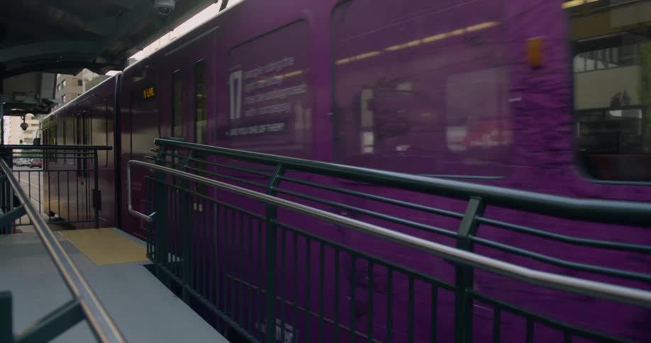 A train passes by a street level platform