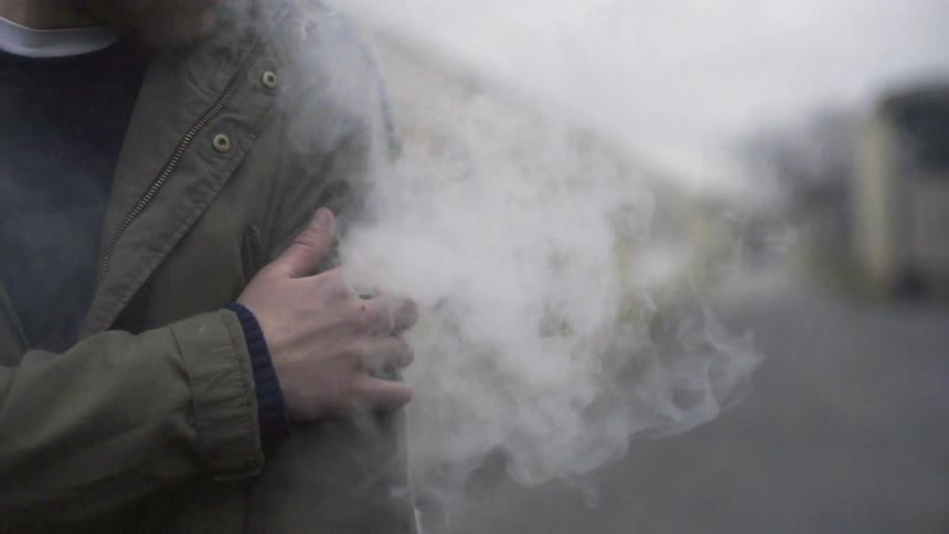 Smoke escapes a man's jacket