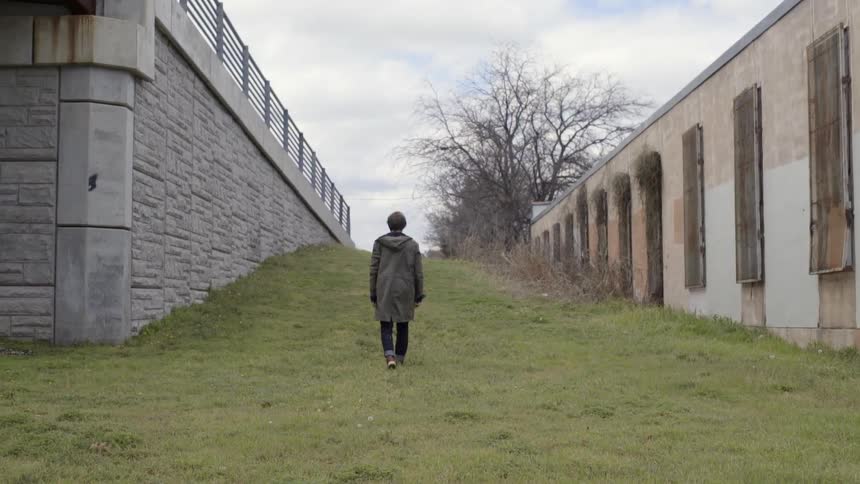Man walking in between two buildings
