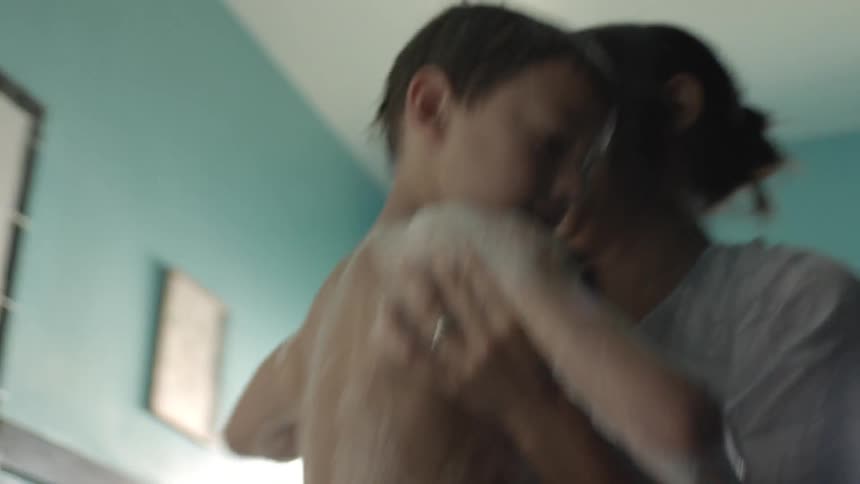 A person picking up a toddler