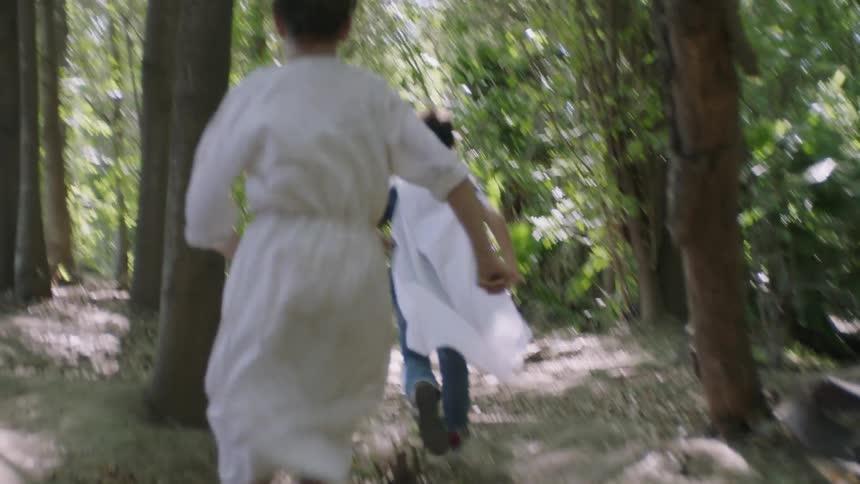 Woman chases a child through a forest