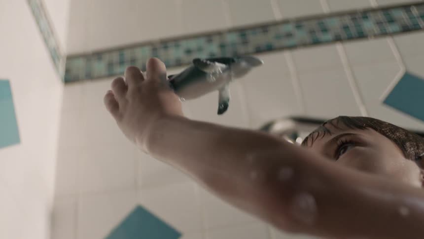 A boy playing with a toy in the bath