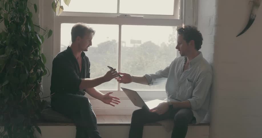 Two men work together on the windowsill