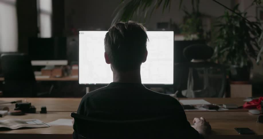 A man sits at his computer working