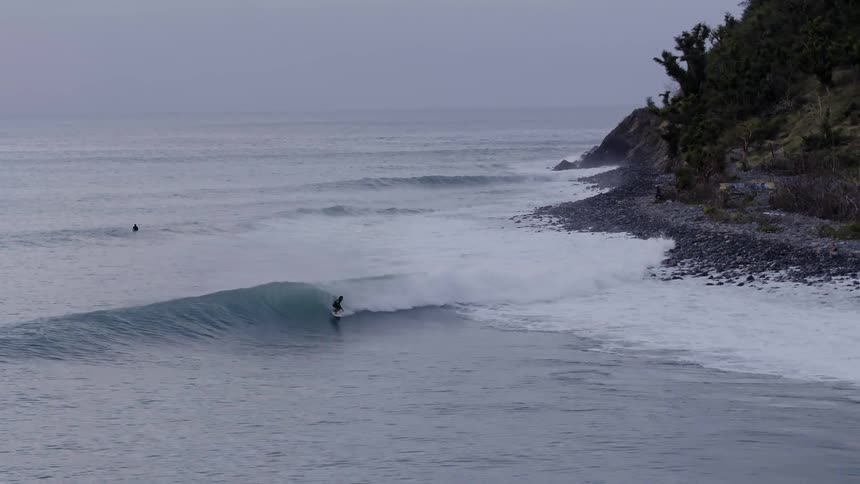 A surfer rides an ocean wave