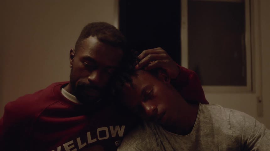 Man consoles another man by rubbing his head