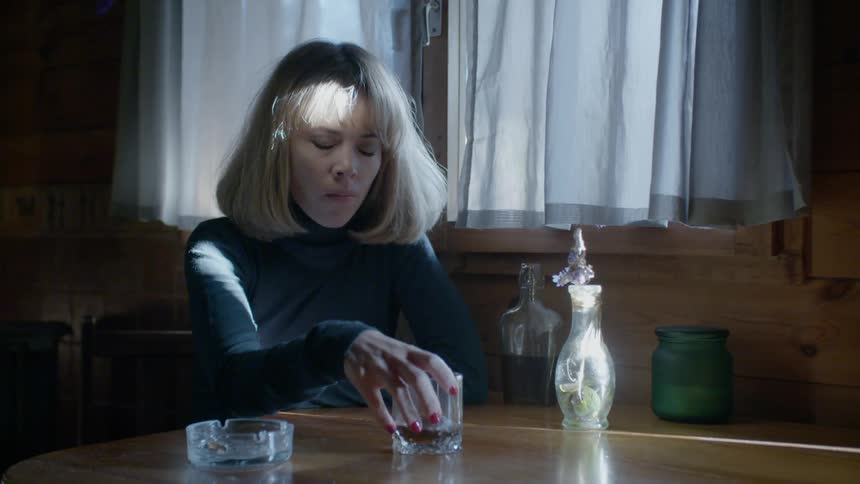 A woman holds her drink as she looks around