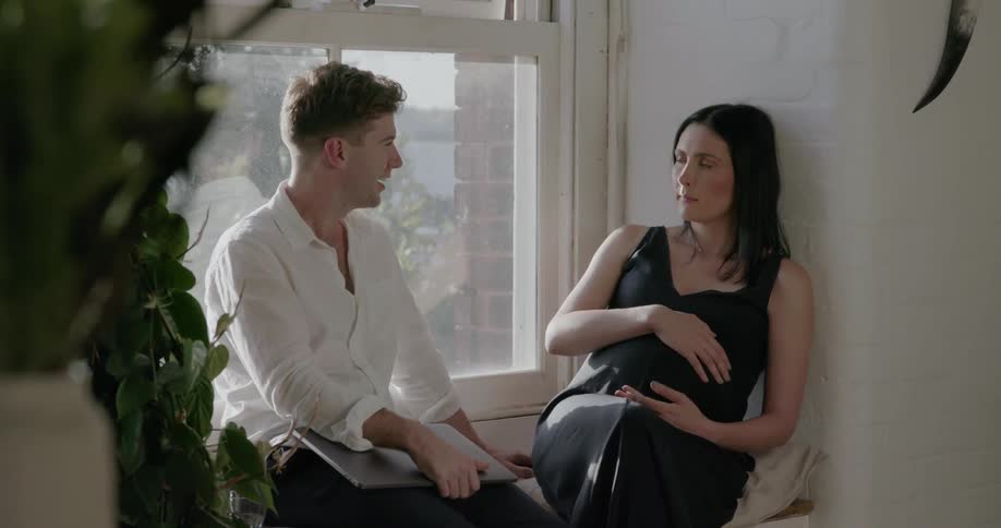 Man and woman sit in front of a window on a sunny day