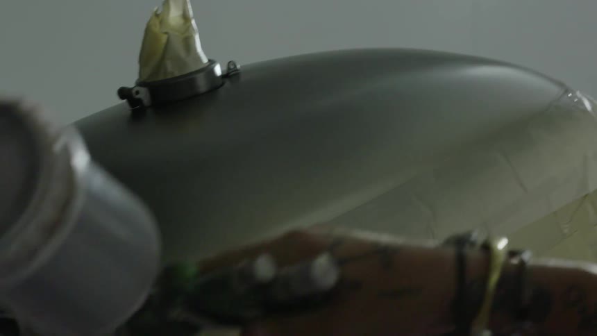 A man is spray painting a metal object
