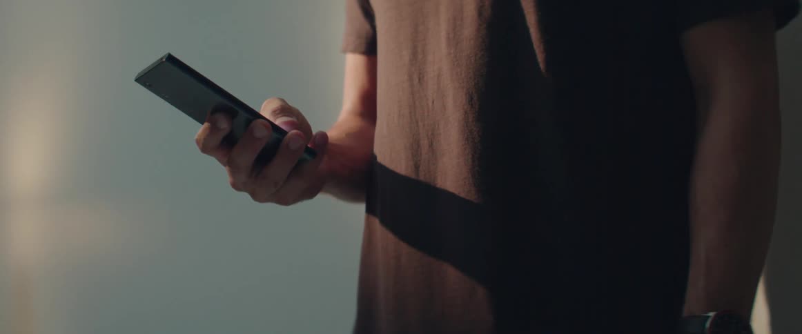 A casual guy checks social media notifications on his touchscreen device at home.
