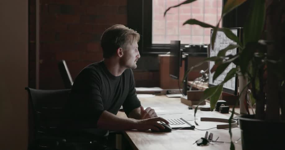 A man sits down to work on a computer