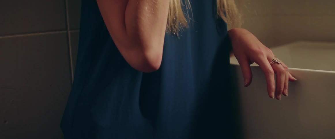 A Women stands inside a room while having an emotionally tense telephone conversation.