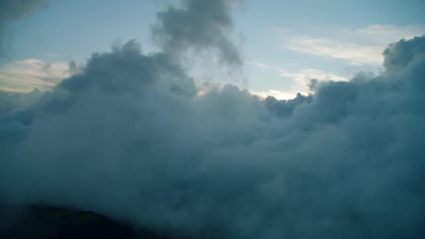 Flying through tall wispy clouds at sunset