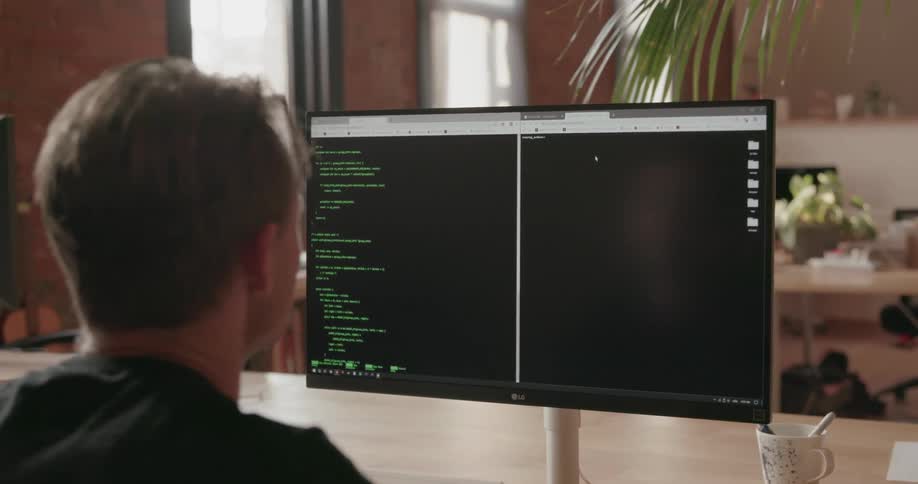 A man is working on code on his computer