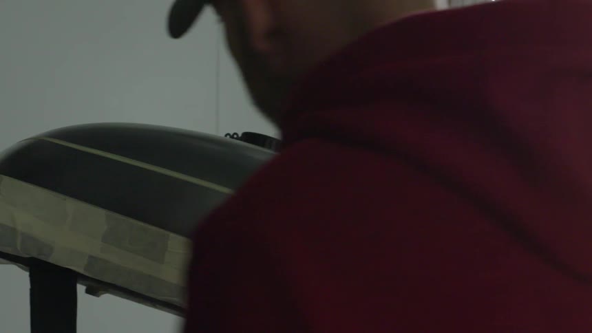 Man spray paints a silver motor