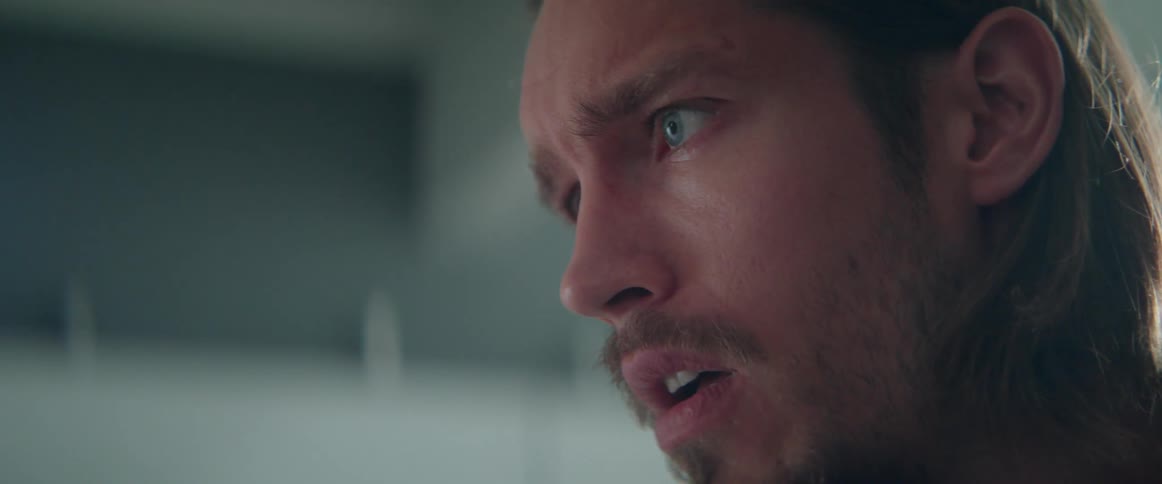 Extreme close up shot of a shocked angry man arguing with someone indoors.