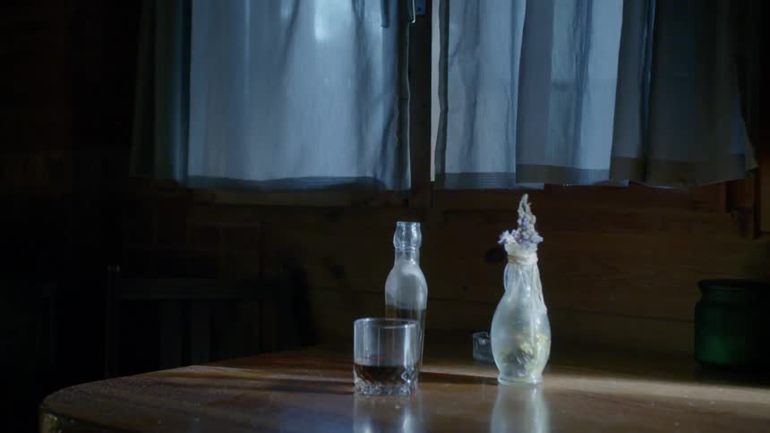 The table has a glass with two bottles
