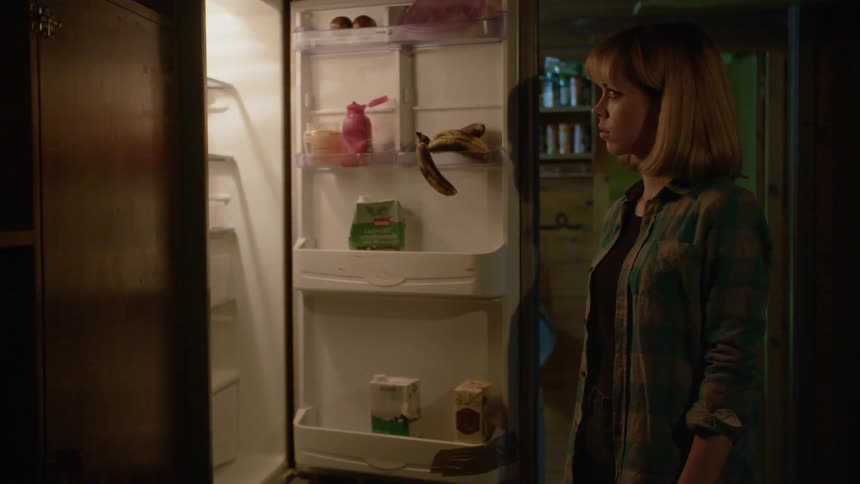 A woman opens a fridge