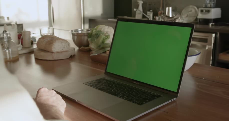 A person is using a laptop at the dining room table