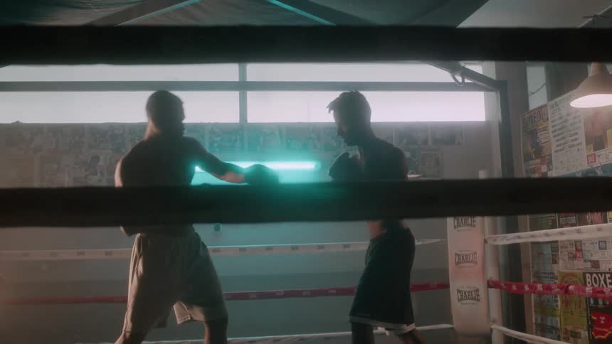 Two men fight in a boxing ring