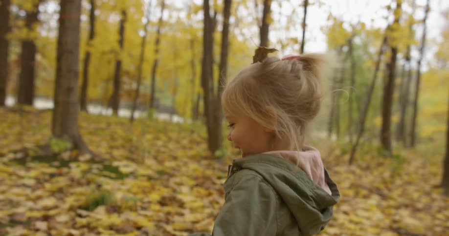 A child laughs as she walks through the forest