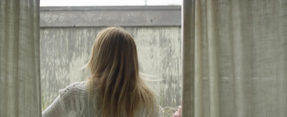 Woman opens patio doors and steps outside