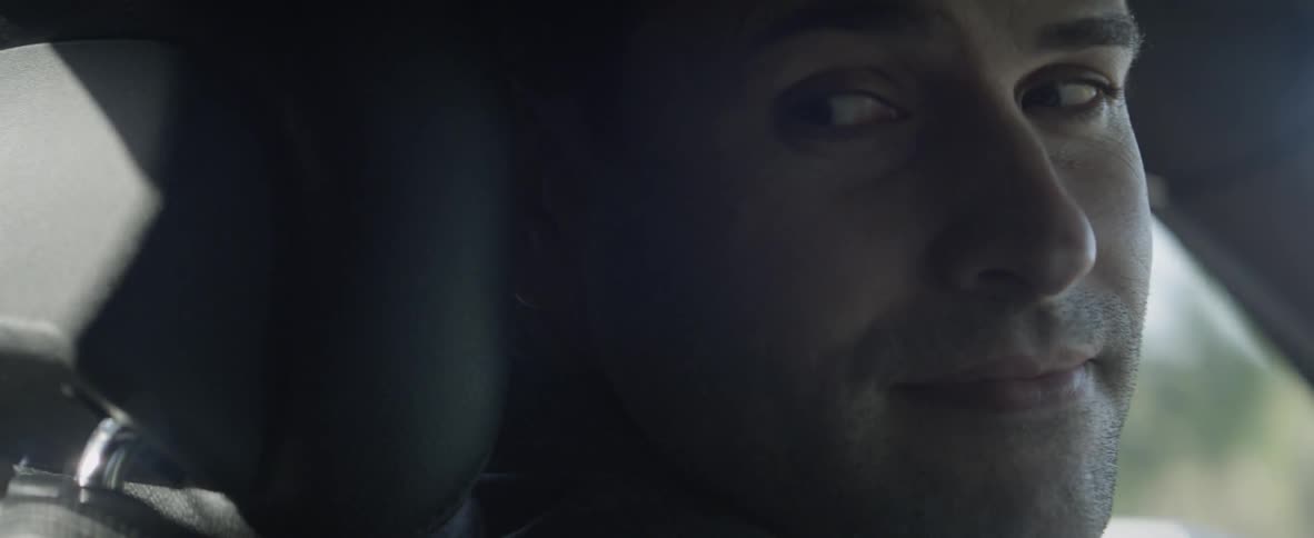 A man is driving the car on a sunny day