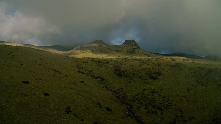 Clouds float above rural mountains