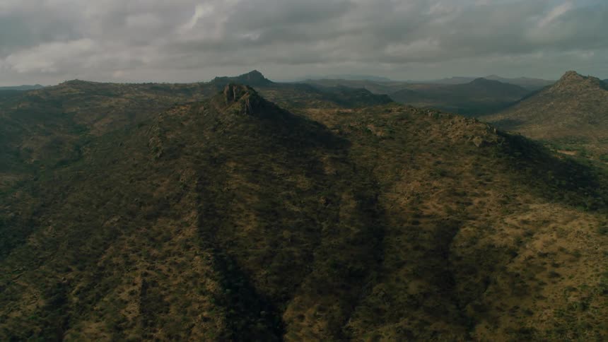 Green grass covered hills are flown over