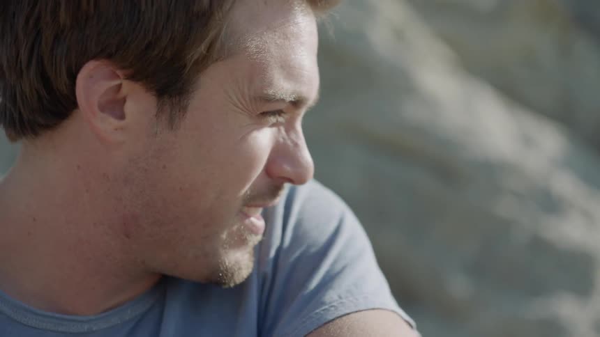 A man is sitting on the beach