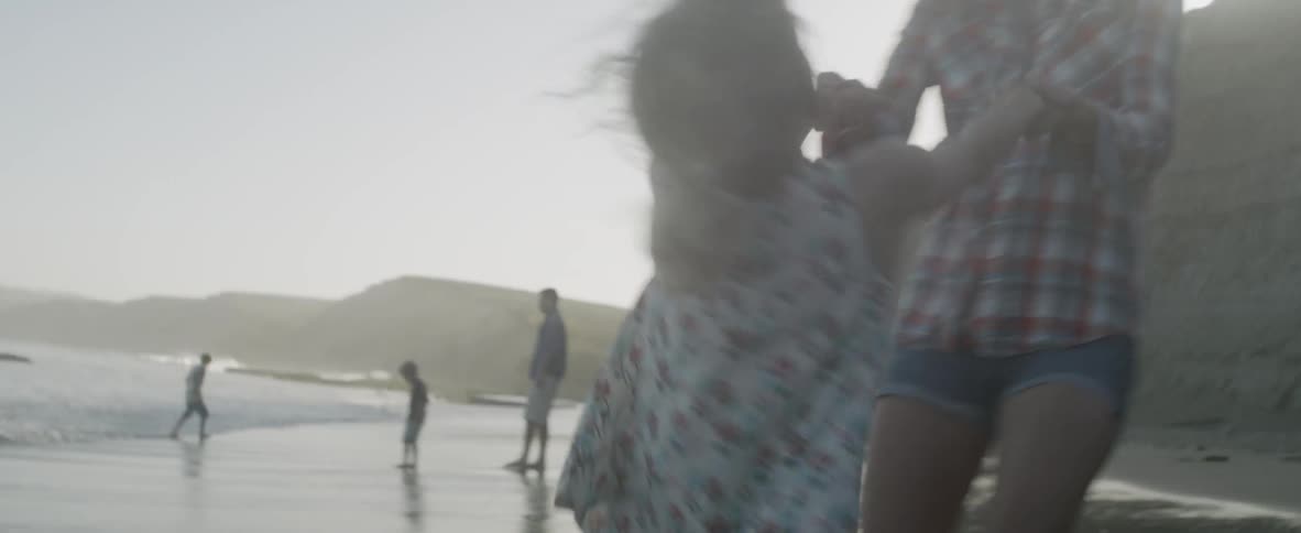 A mother and daughter spin hand in hand, caught in a moment of pure joy