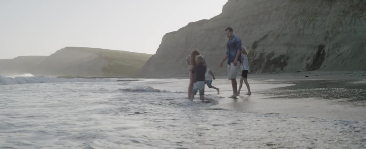 Man woman and children play on the beach