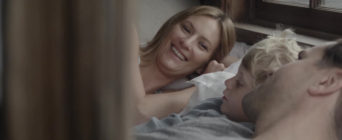 A family talks while lying in bed