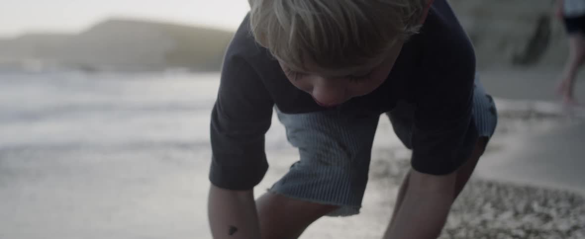 Child digs in the sand on the beach
