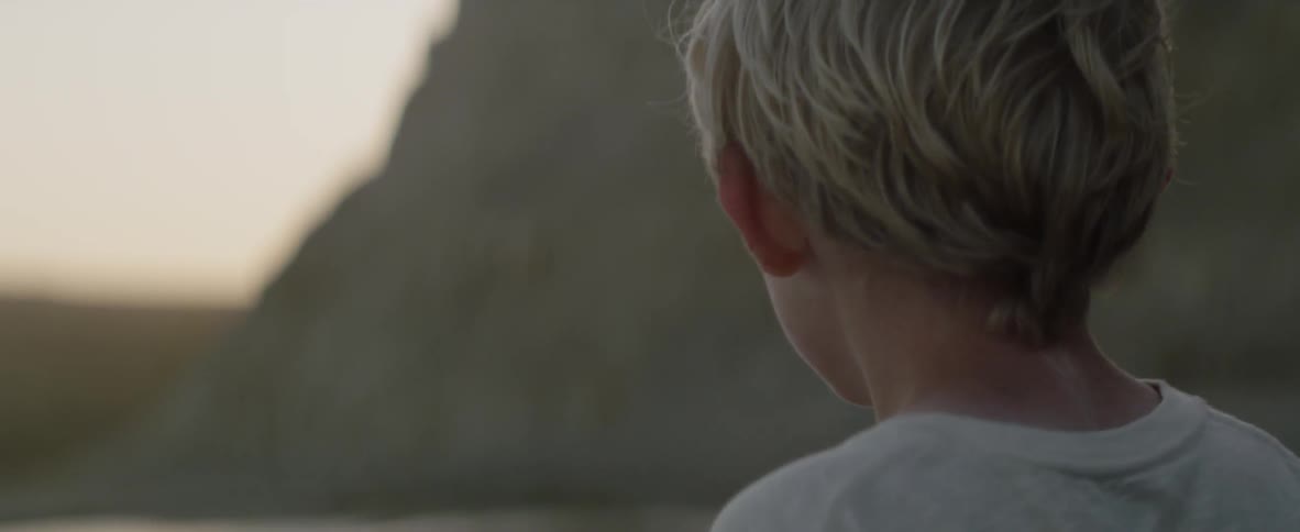 A boy standing outside looks around