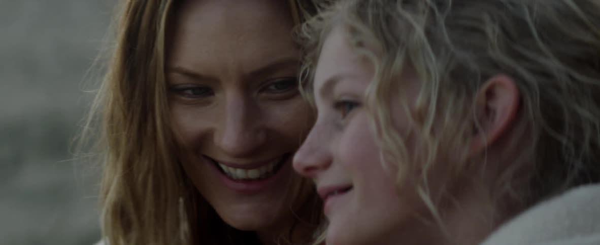 A mother and daughter smile and laugh