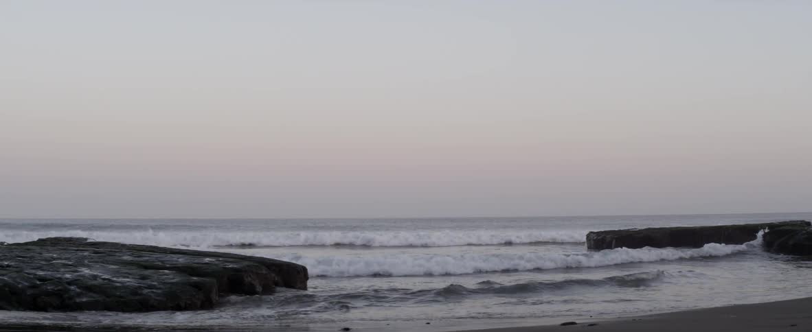 Ocean waves wash ashore at sunset